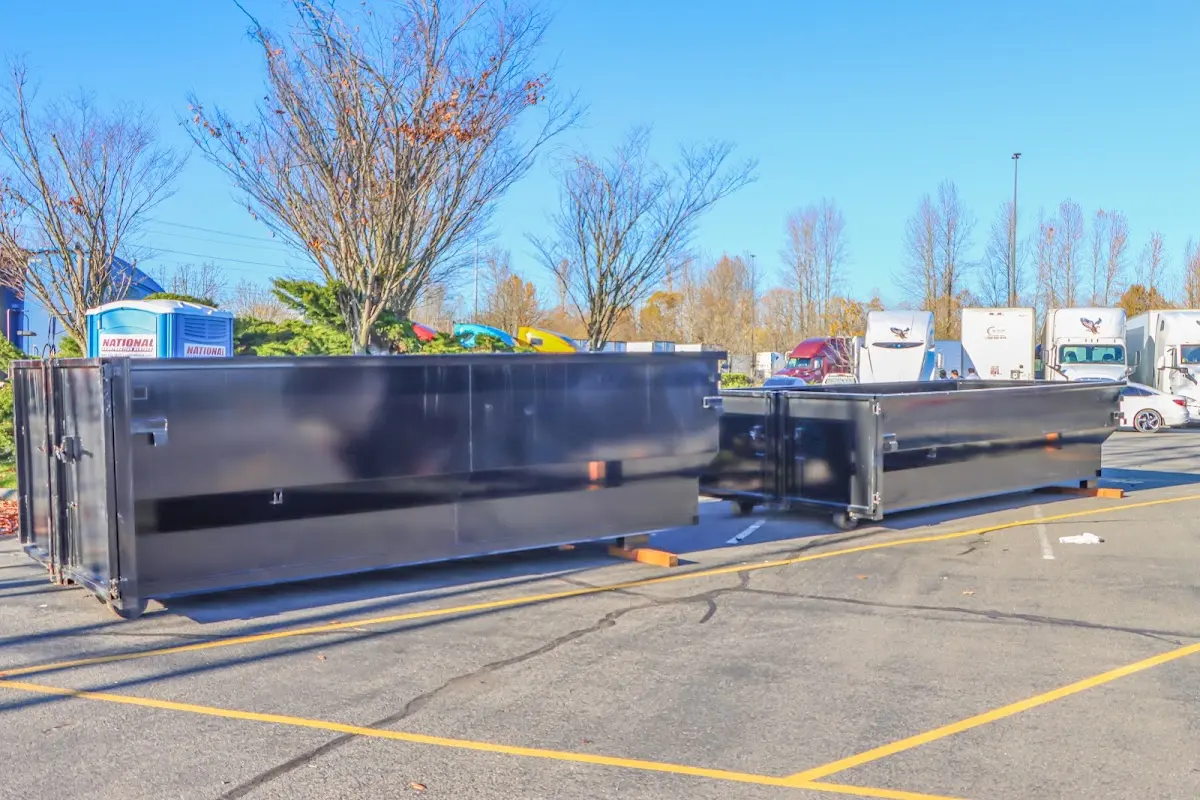 Professional dumpster rental service with roll-off container on residential driveway in Montevideo